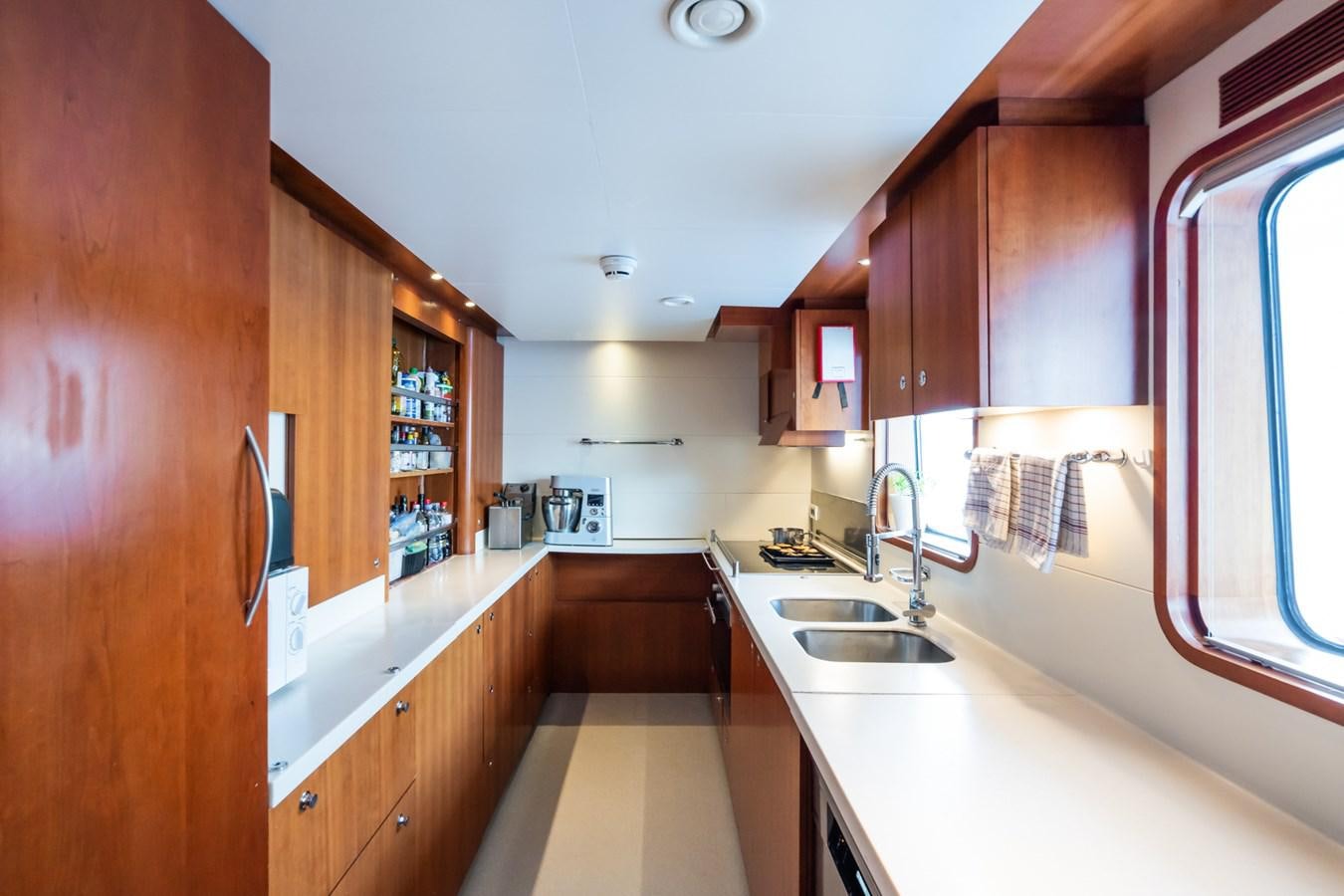 a kitchen with wooden cabinets aboard CORNELIA Yacht for Sale