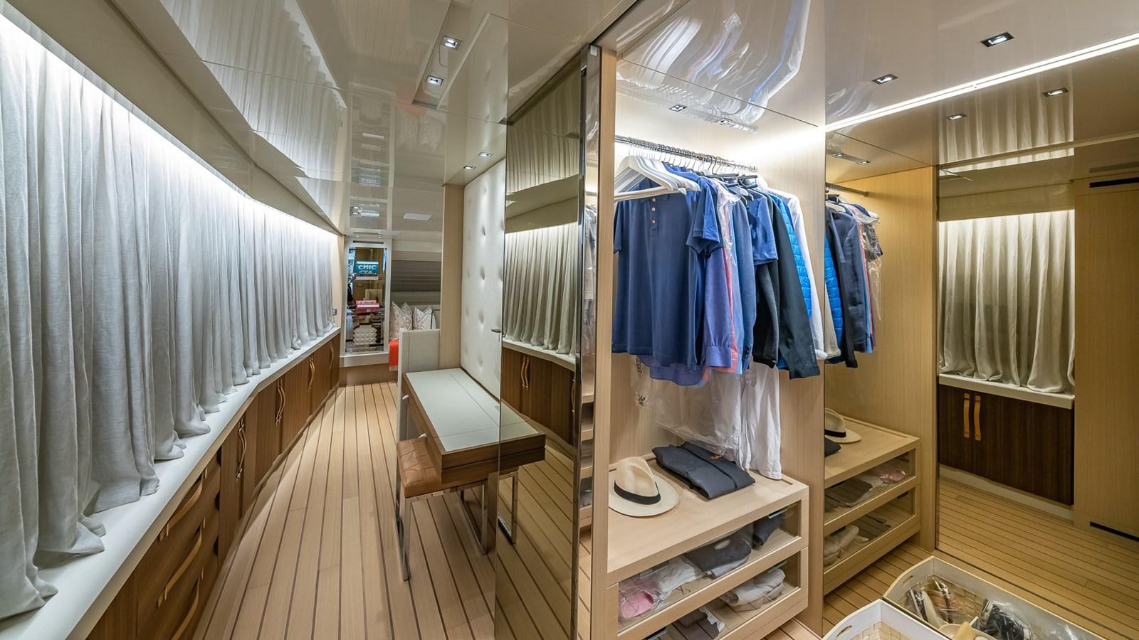 a room with a closet and clothes on the rack aboard XWAVE Yacht for Sale