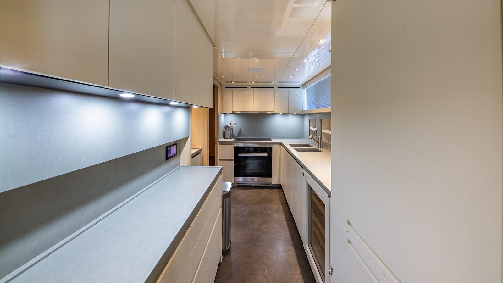 a kitchen with white cabinets aboard XWAVE Yacht for Sale