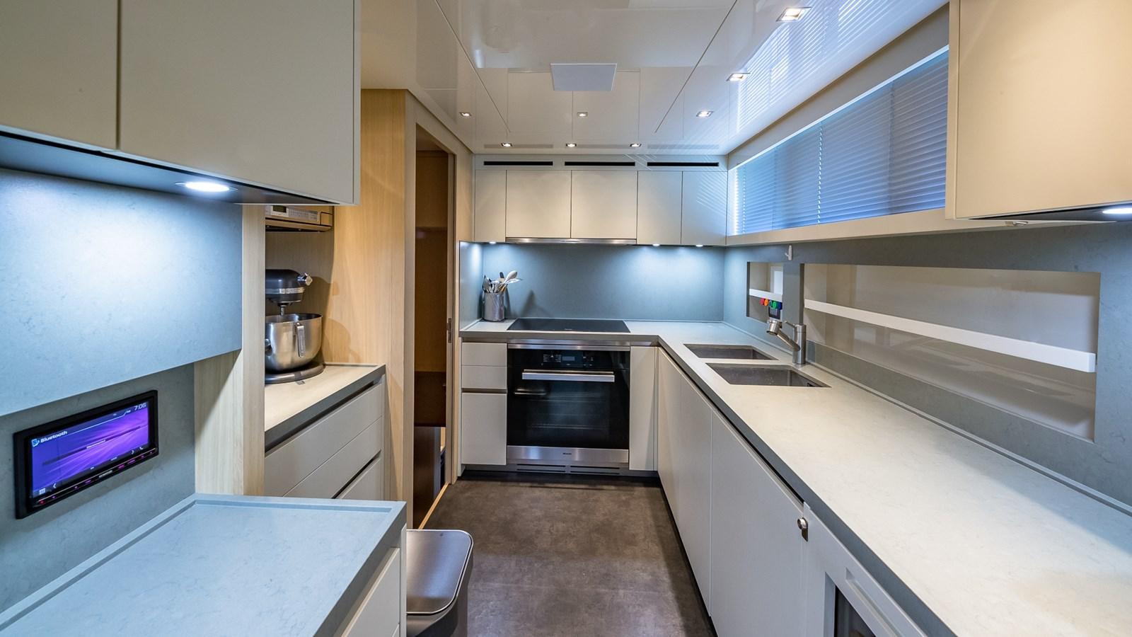 a kitchen with white cabinets aboard XWAVE Yacht for Sale