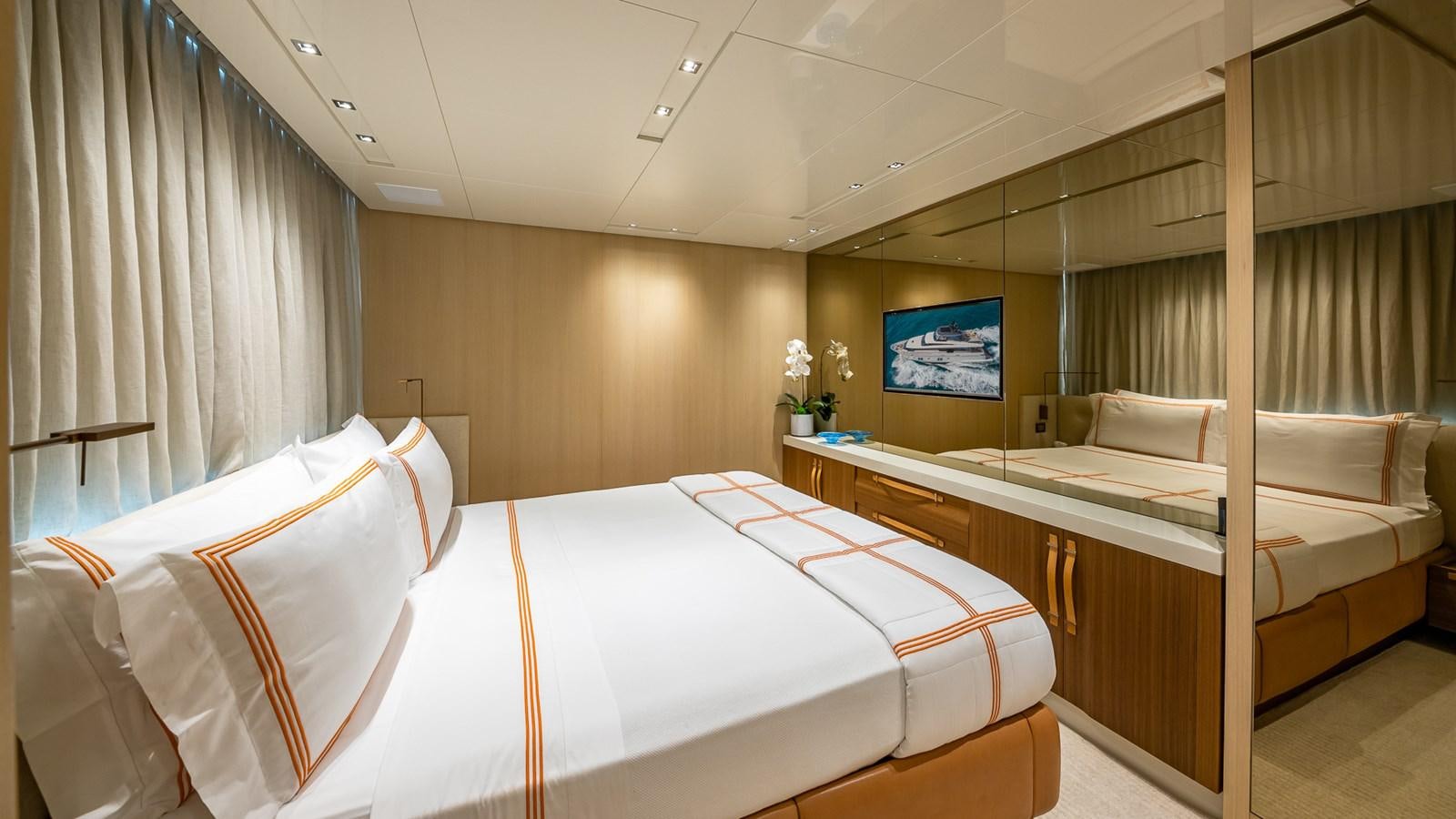 a room with a bed and a tv on the wall aboard XWAVE Yacht for Sale