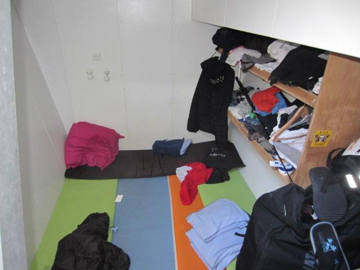 a room with bunk beds and clothes on the floor aboard ECOLORATO Yacht for Sale