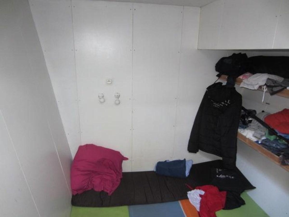 a room with clothes and a bed aboard ECOLORATO Yacht for Sale