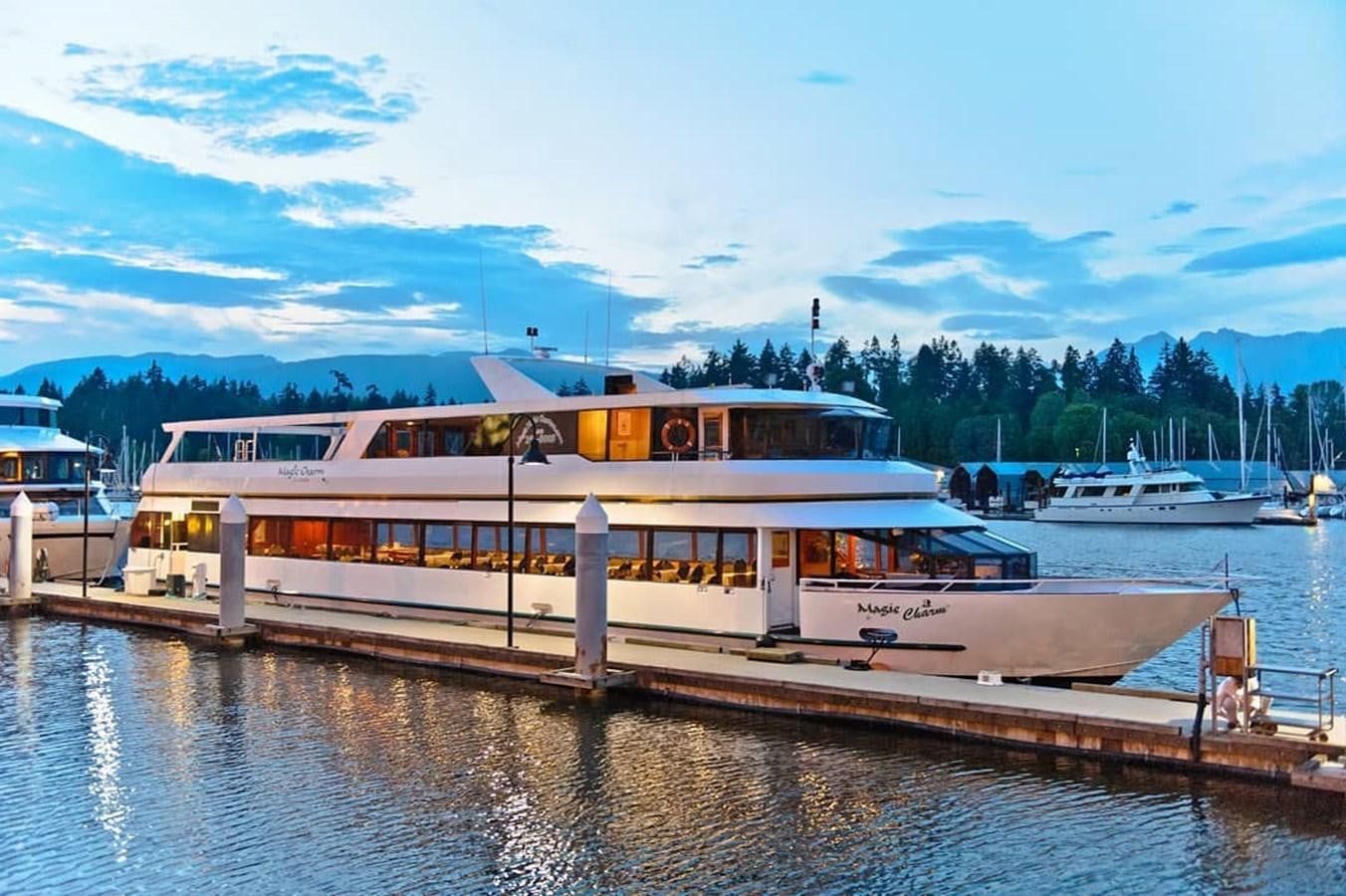 a large white boat sits at a dock aboard MAGIC CHARM Yacht for Sale