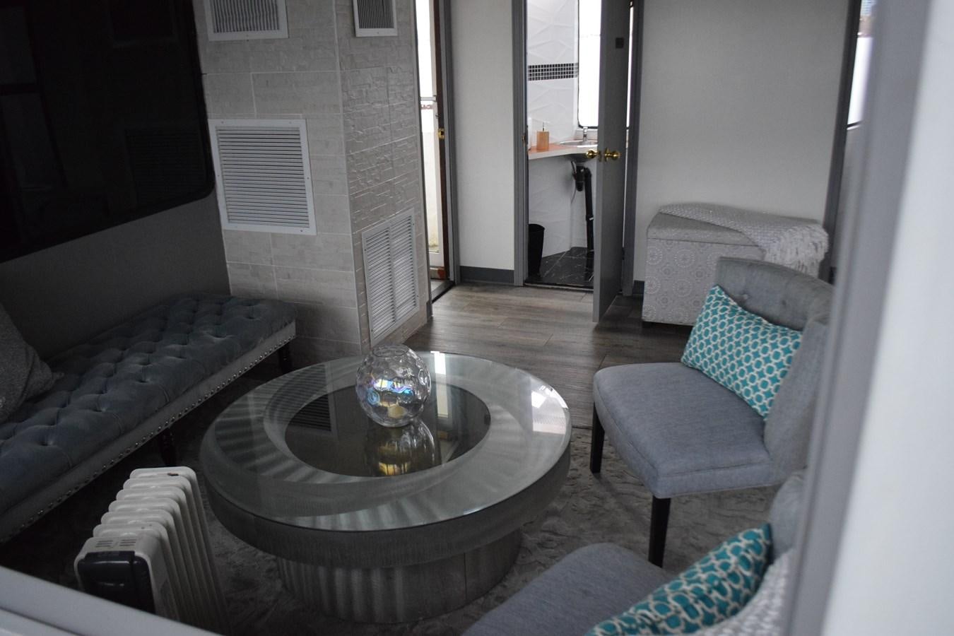 a living room with a round table aboard MAGIC CHARM Yacht for Sale