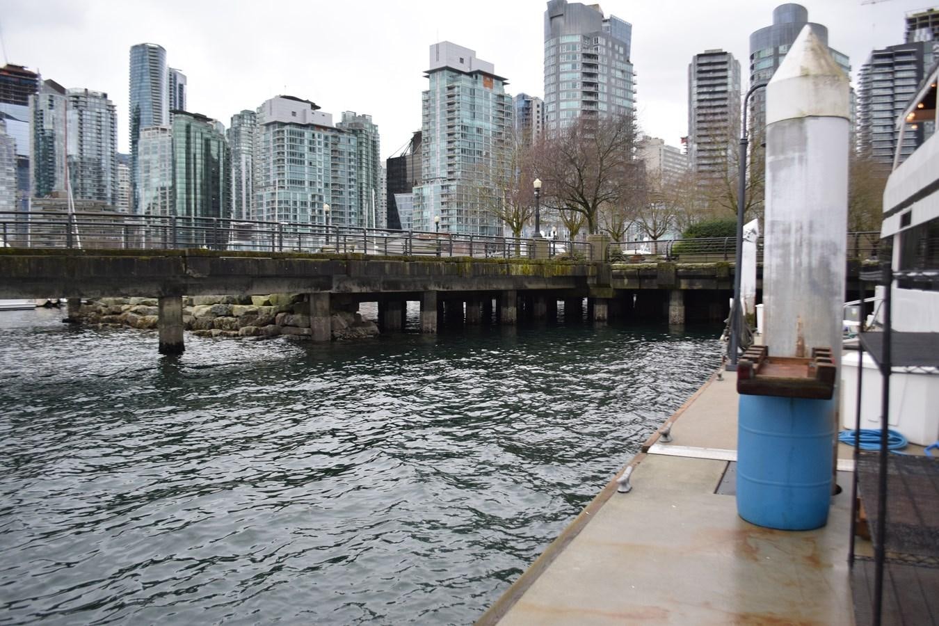 a dock with a body of water and a city in the background aboard MAGIC CHARM Yacht for Sale