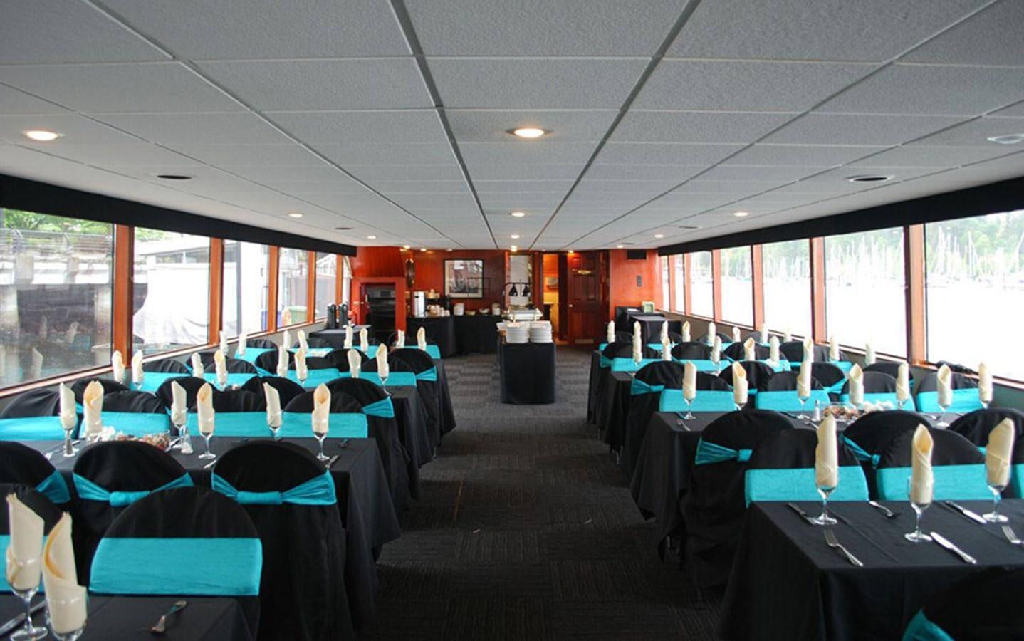 a room with tables and chairs aboard MAGIC CHARM Yacht for Sale