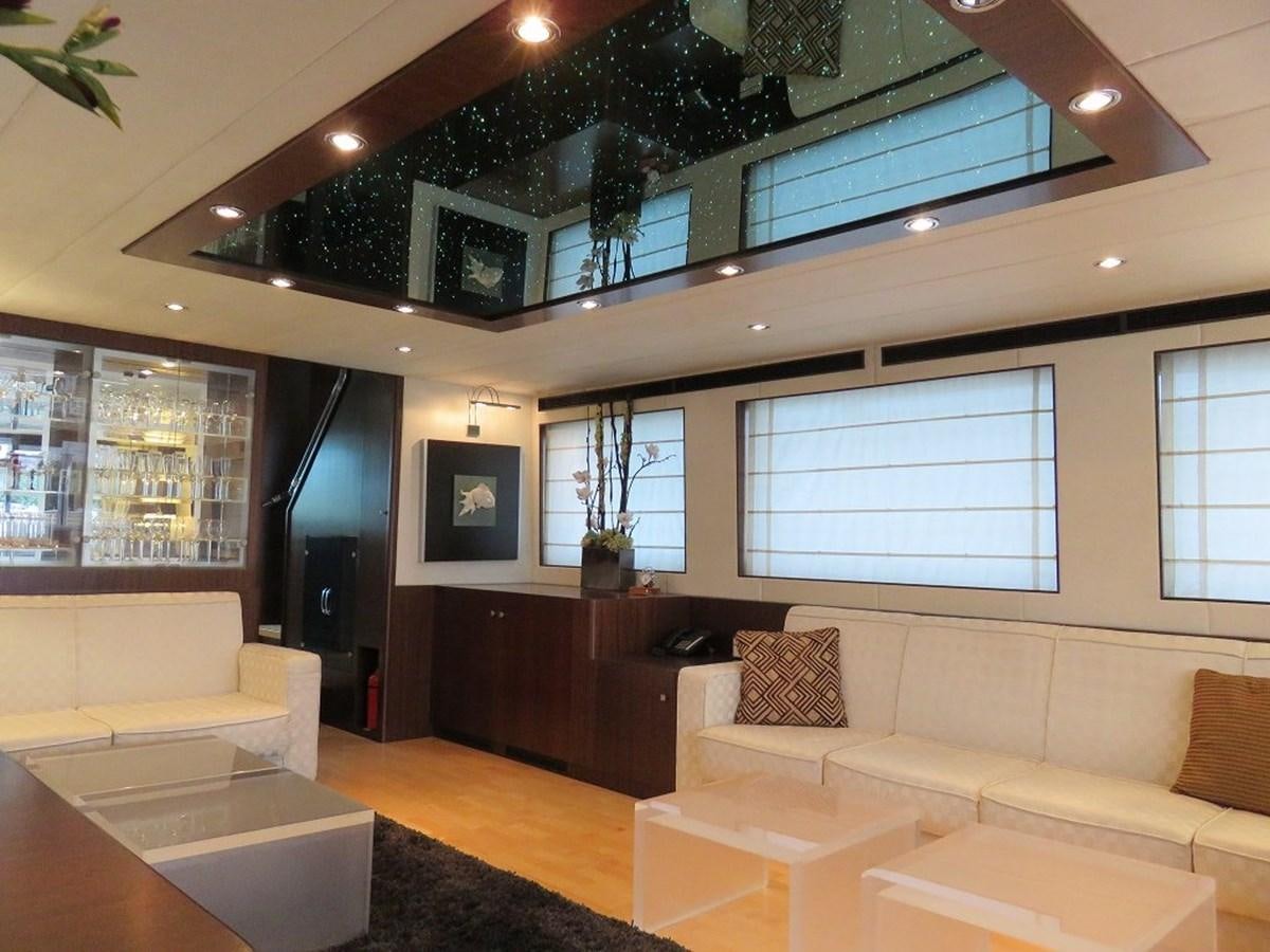 a room with a couch and a table and a window aboard ANA Yacht for Sale