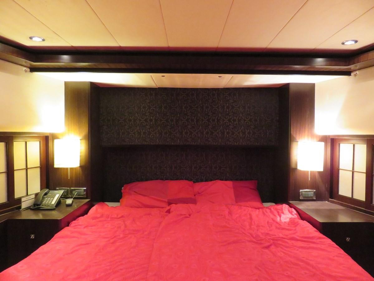 a bed with red sheets aboard ANA Yacht for Sale