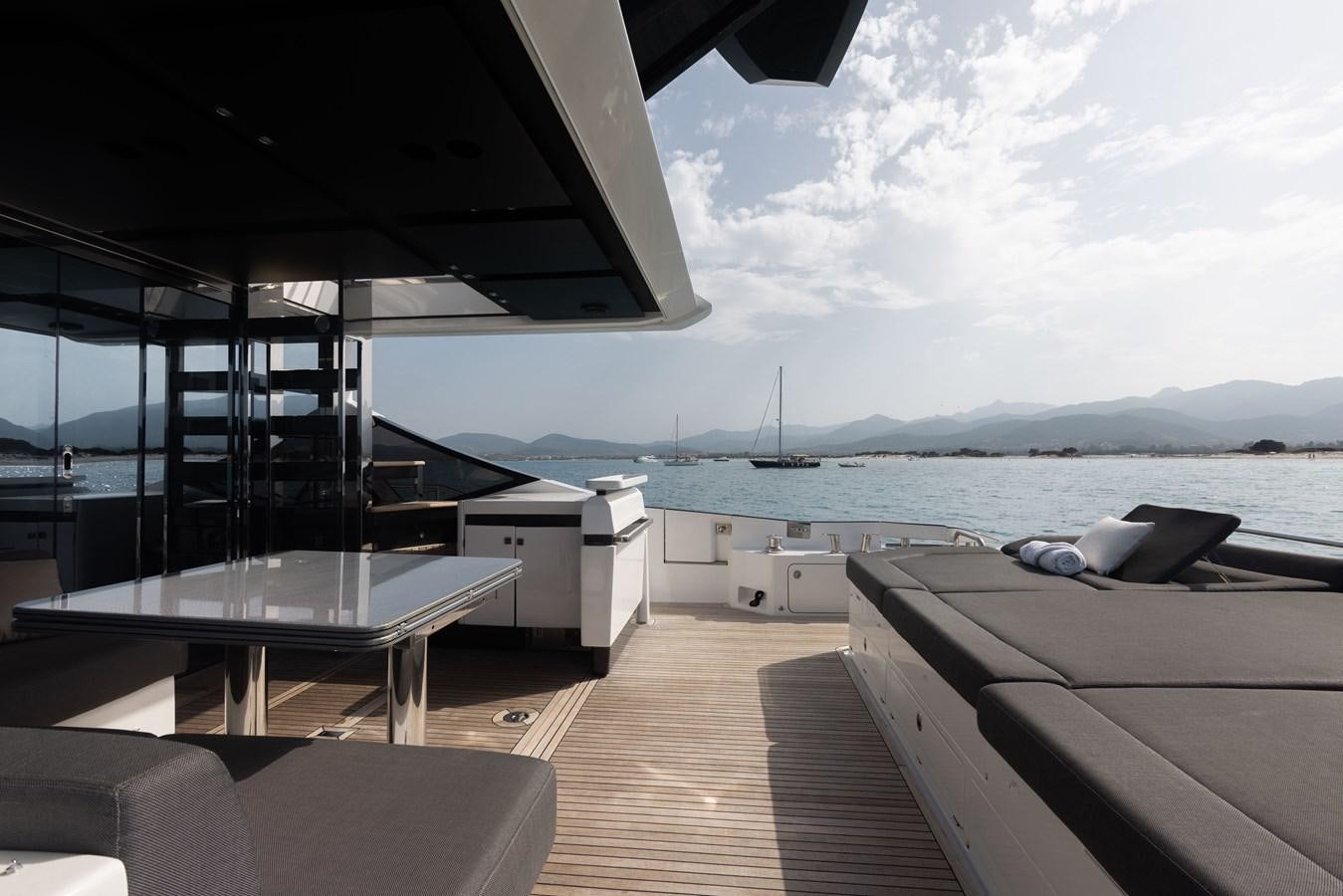 a deck with a view of the ocean and the mountains aboard ESCAPE Yacht for Sale