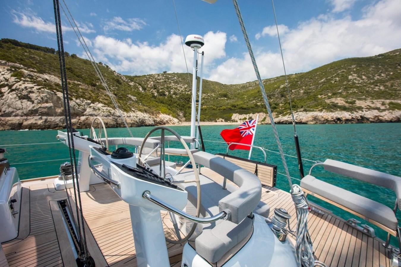 a boat with a flag on the front aboard VAYU Yacht for Sale