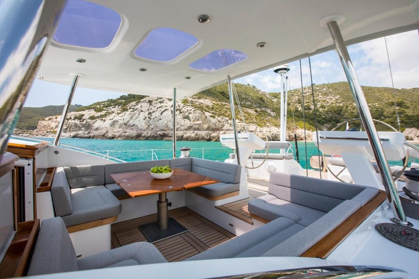 a room with a table and chairs aboard VAYU Yacht for Sale