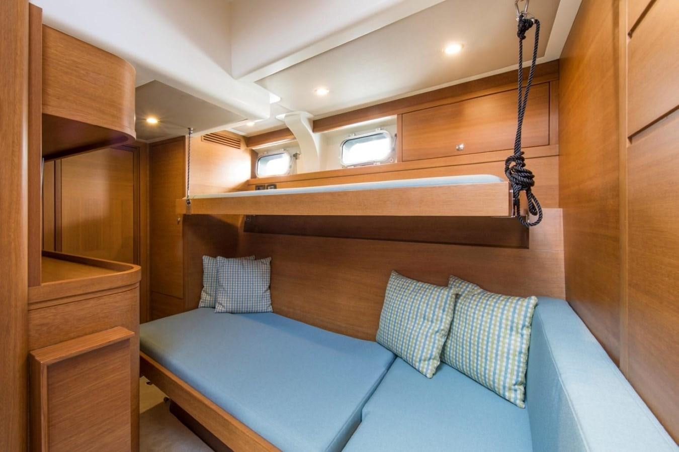 a room with a bed and a wood cabinet aboard VAYU Yacht for Sale