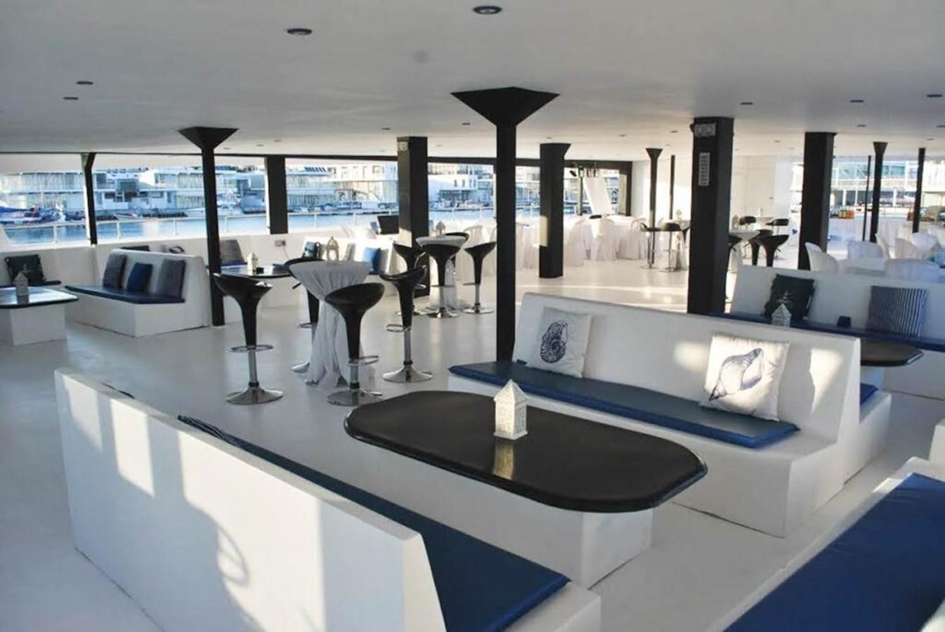 a room with a couch and a table with chairs aboard SALONE Yacht for Sale