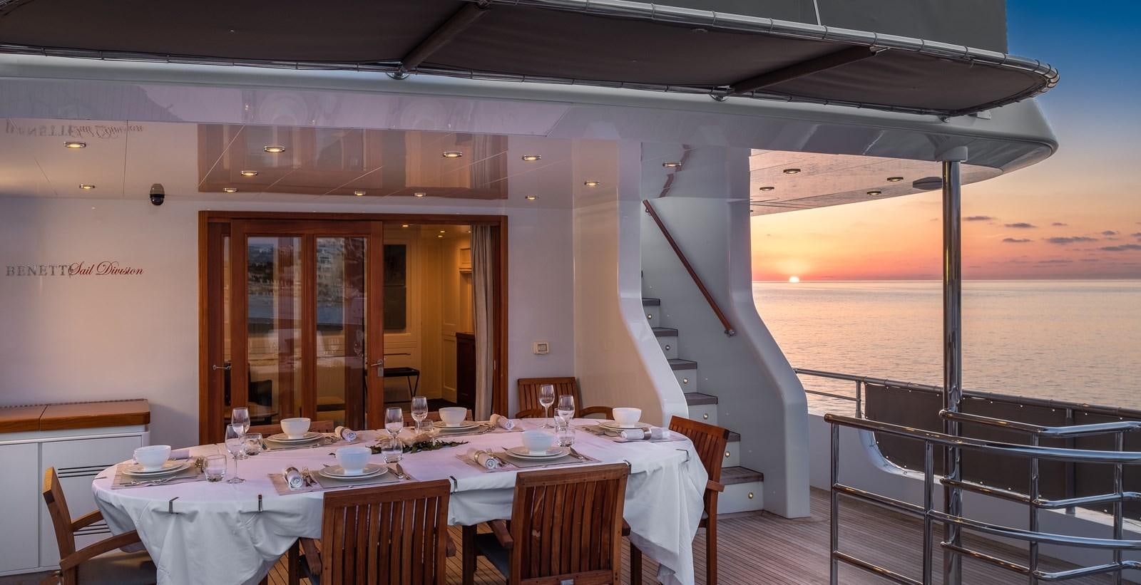 a table set for a meal on a deck overlooking the ocean aboard EVERGREEN G Yacht for Sale