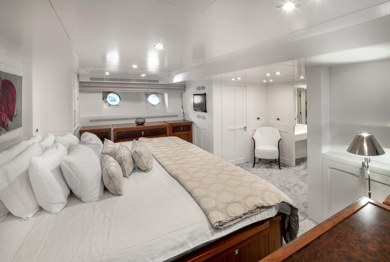a bedroom with a bed and a chair aboard EVERGREEN G Yacht for Sale