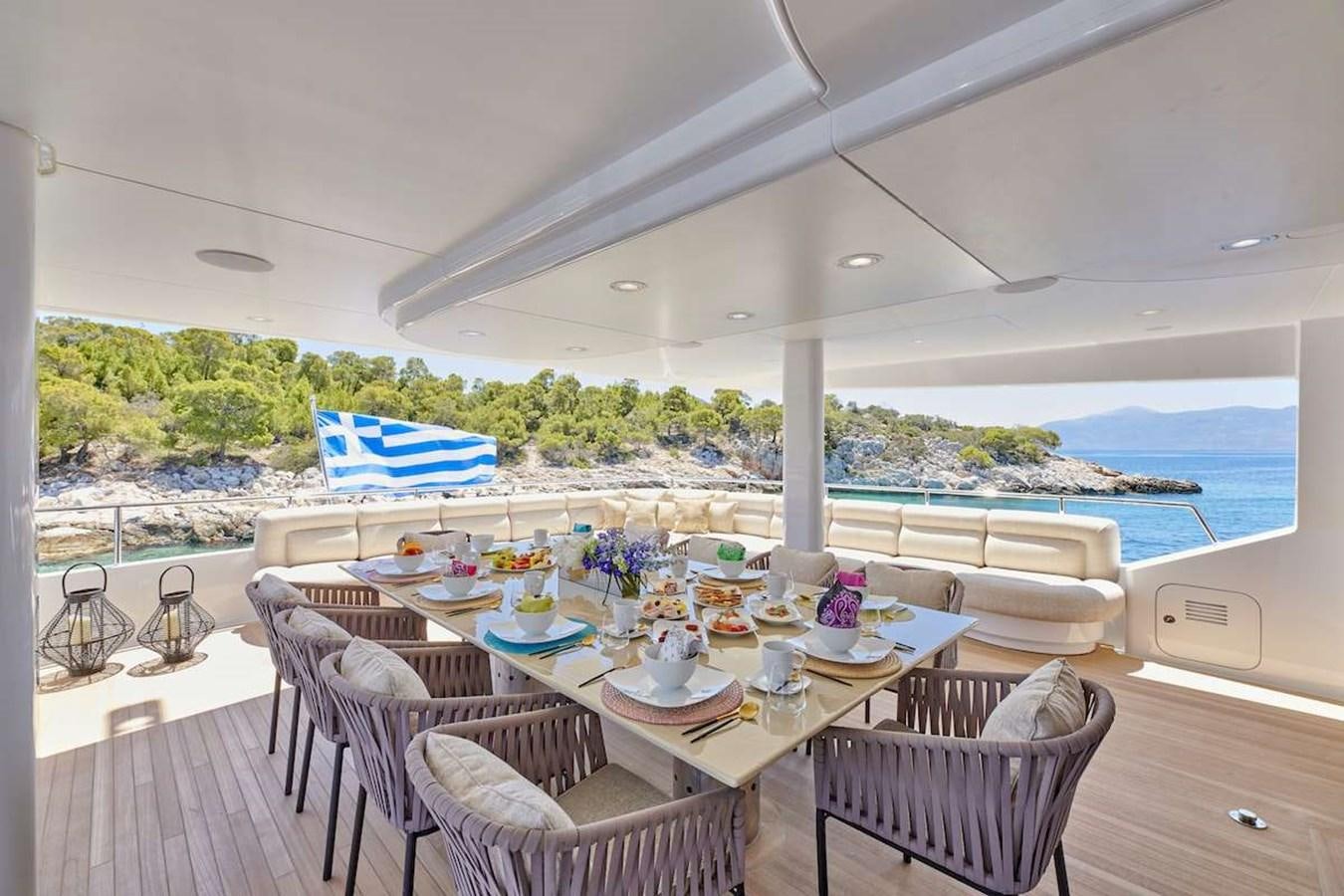 a table set for a meal on a deck overlooking the ocean aboard DALOLI Yacht for Sale