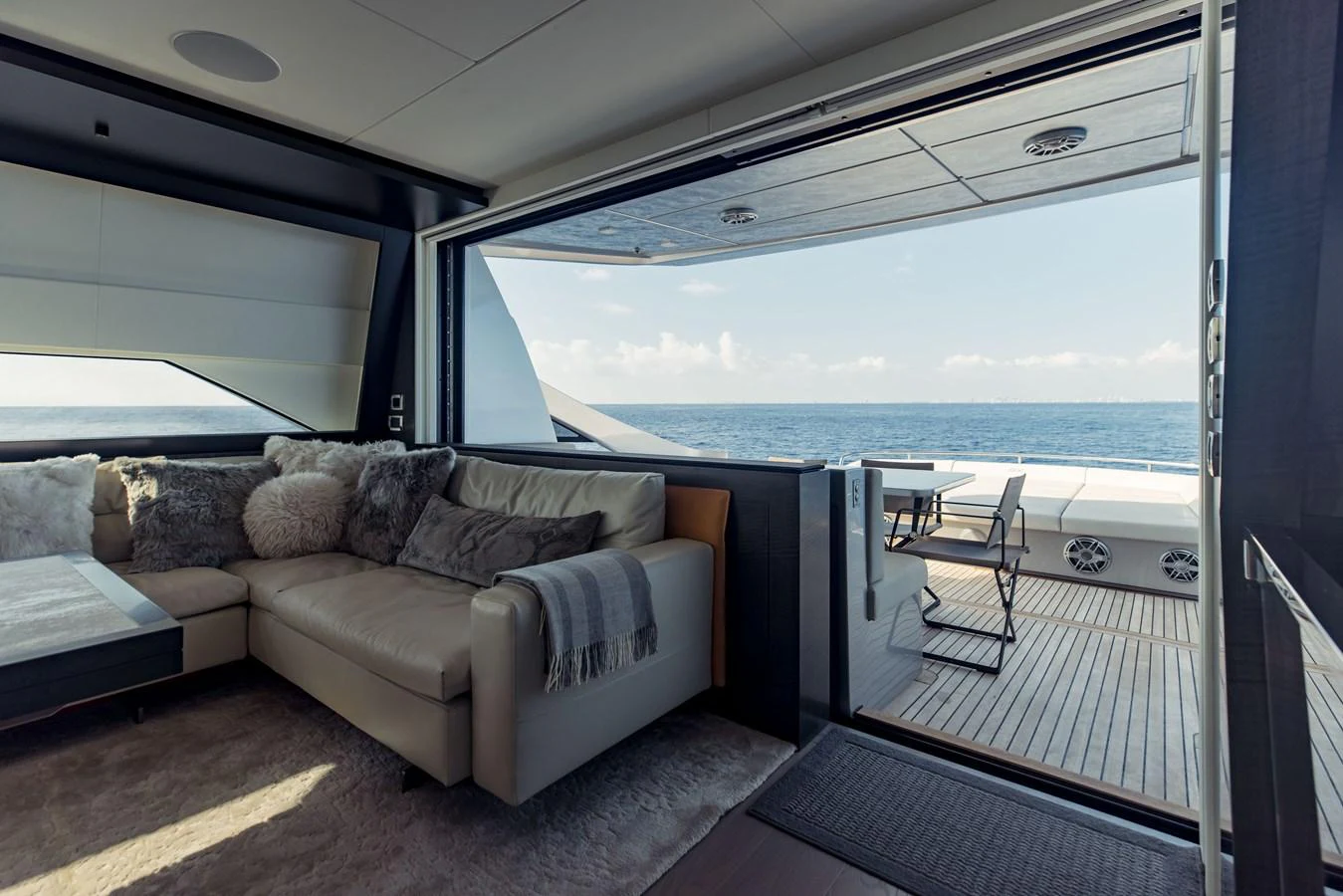 a couch and a table in a room with a large window aboard STALLION Yacht for Sale