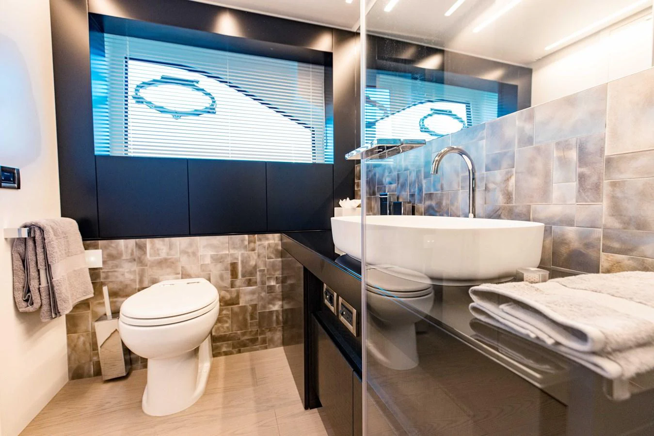 a bathroom with a sink toilet and a mirror aboard STALLION Yacht for Sale