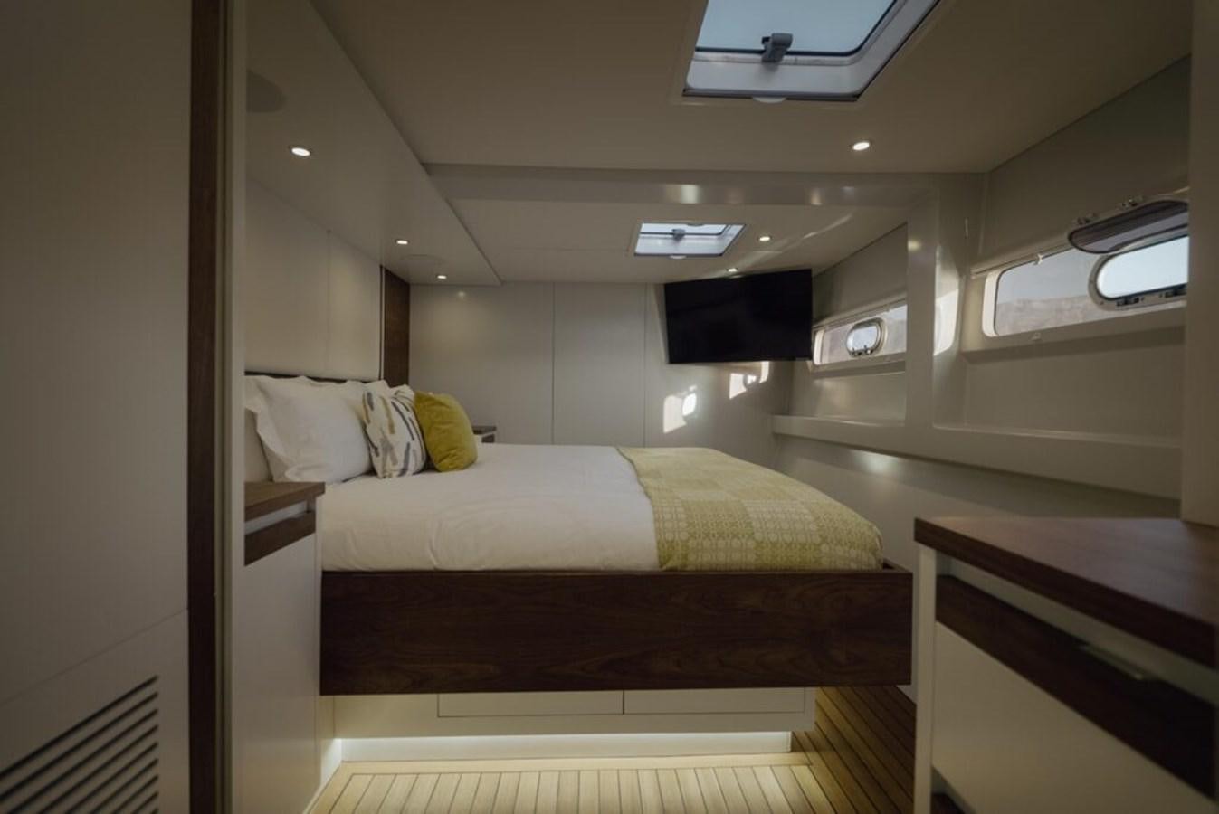 a room with a bed and a tv on the wall aboard SALTY Yacht for Sale