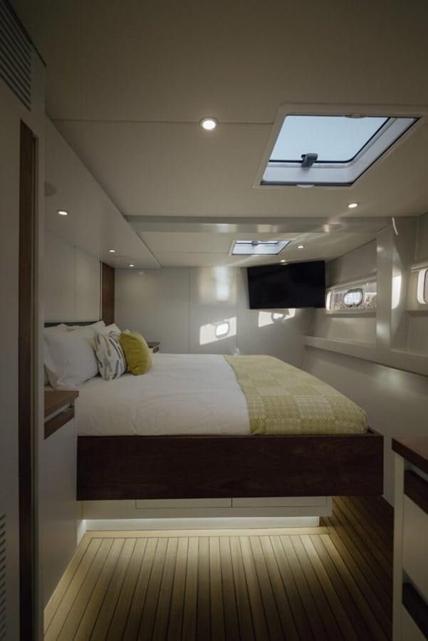 a bed with a television on the wall aboard SALTY Yacht for Sale