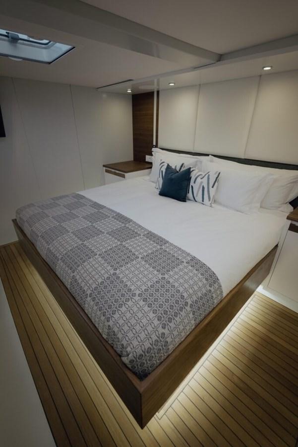 a bed with a white comforter aboard SALTY Yacht for Sale