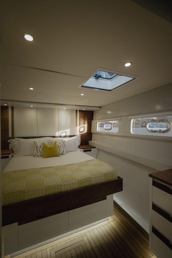 a bedroom with a bed and a mirror aboard SALTY Yacht for Sale