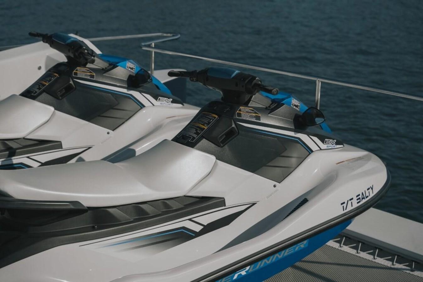 a white boat with blue water and a helicopter on it aboard SALTY Yacht for Sale