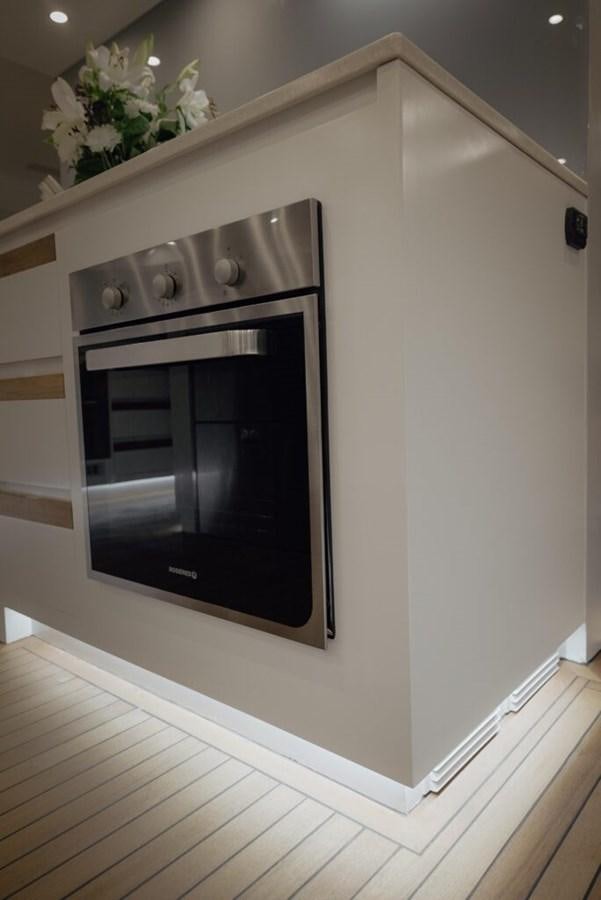a white kitchen with a black oven aboard SALTY Yacht for Sale