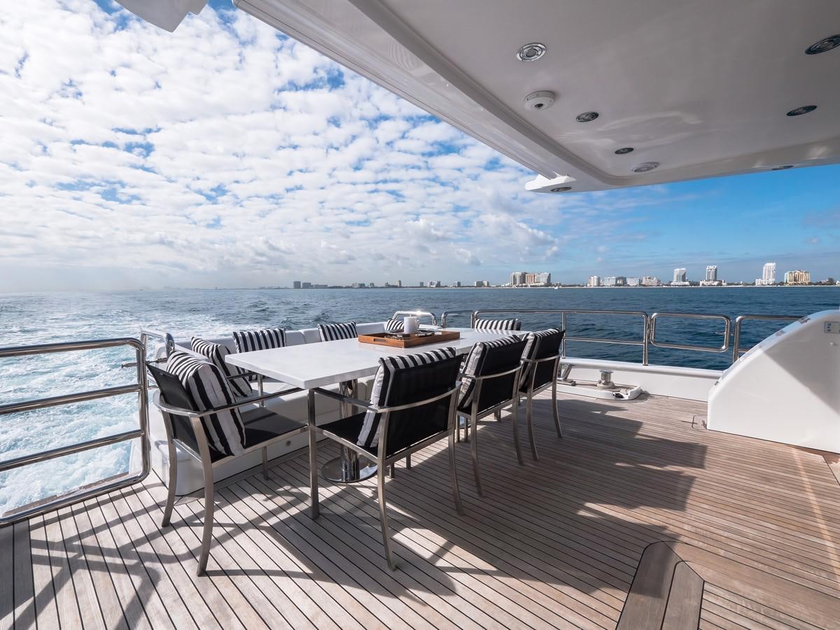 a table and chairs on a deck overlooking a large body of water aboard 2016 AZIMUT 76 MAGELLANO THE EQUITES Yacht for Sale