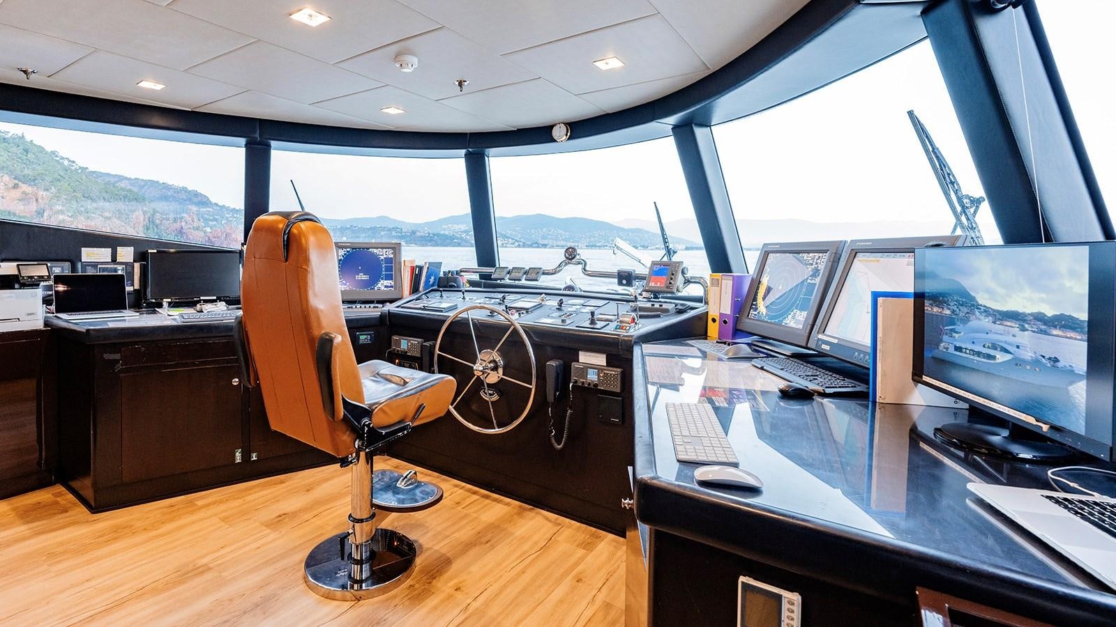 a chair in front of a desk with a computer on it aboard LOTUS Yacht for Sale