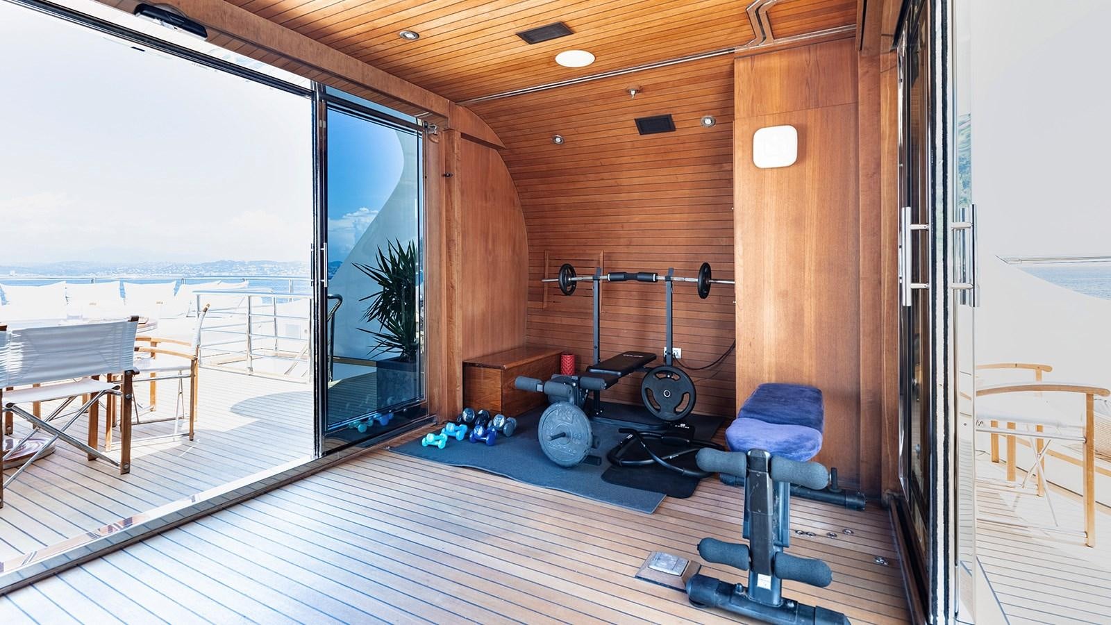 a room with a wood floor and a large window with a view of the ocean aboard LOTUS Yacht for Sale