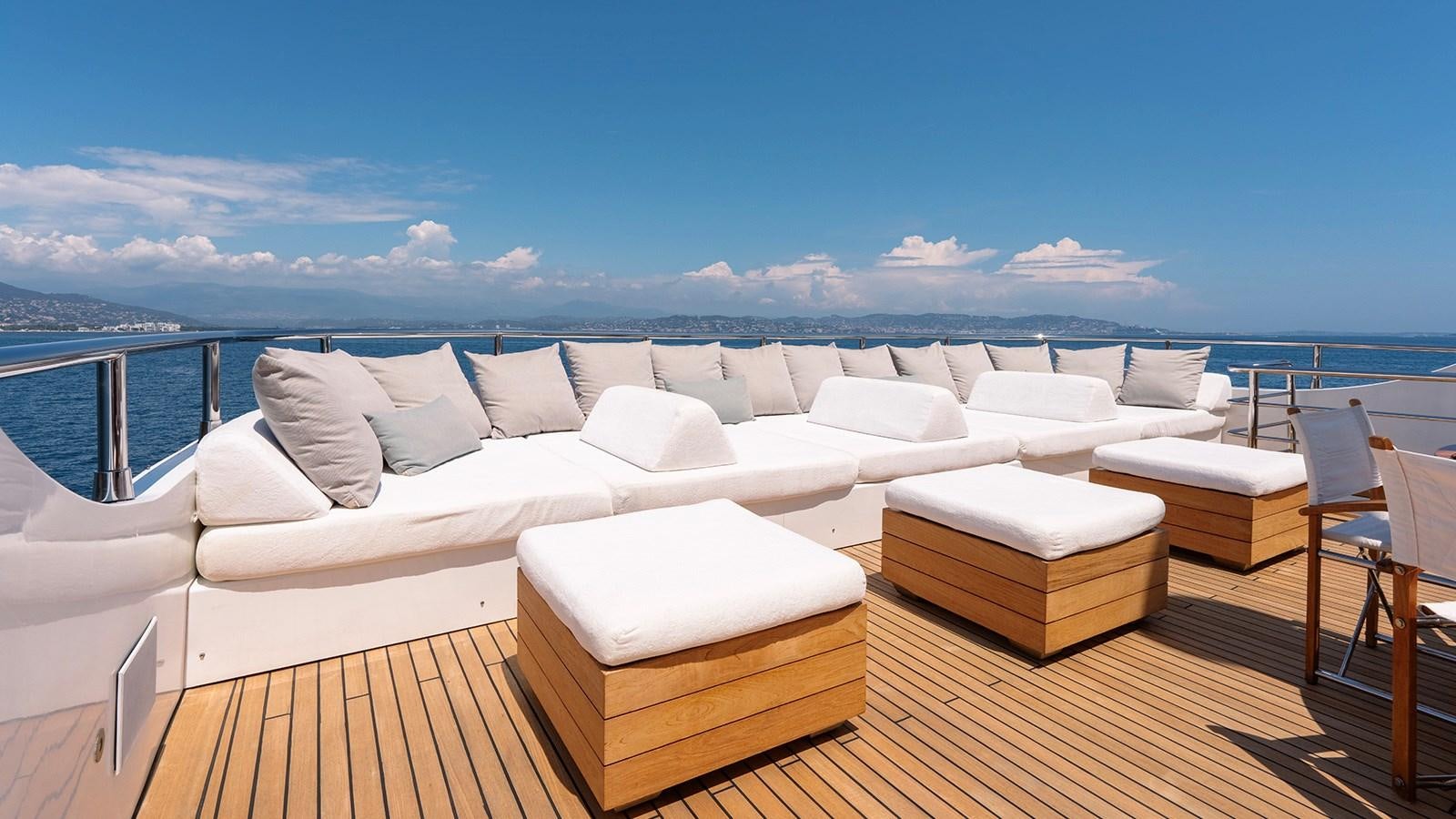 a deck with a large body of water and a large boat in the background aboard LOTUS Yacht for Sale