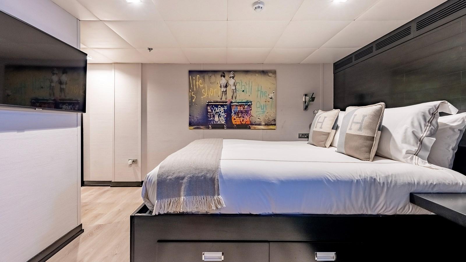 a bedroom with a bed and a tv aboard LOTUS Yacht for Sale