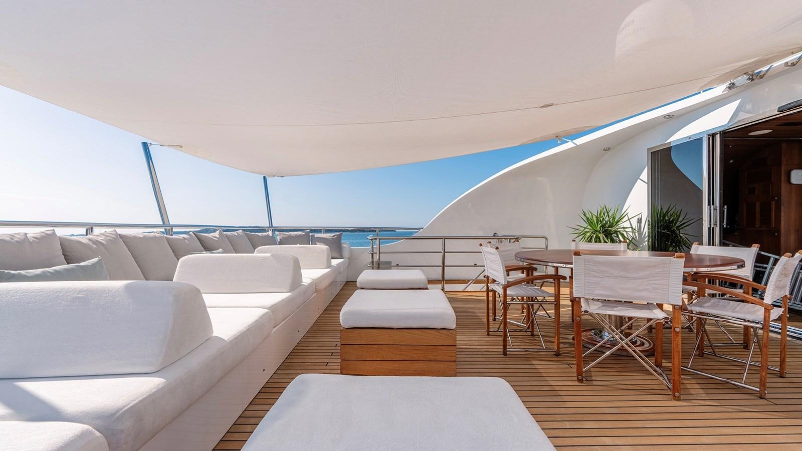 a room with a couch and a table and chairs aboard LOTUS Yacht for Sale