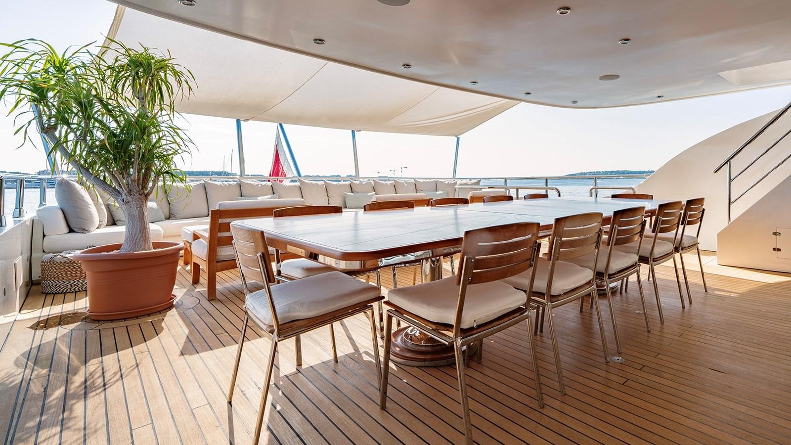 a large room with a table and chairs and a plant aboard LOTUS Yacht for Sale