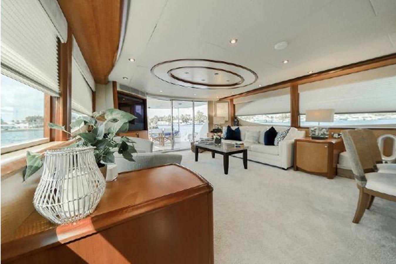 a room with a large window and a table with chairs and a large window aboard 2007 LAZZARA 84 MOTOR Yacht for Sale