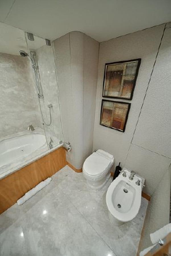 a bathroom with a toilet and tub aboard 2007 LAZZARA 84 MOTOR Yacht for Sale