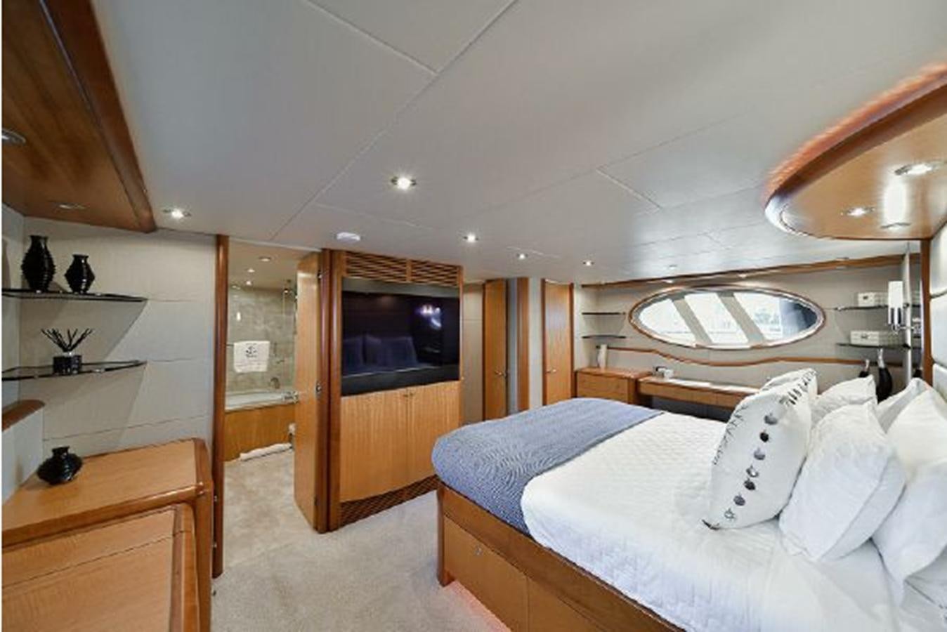 a bedroom with a bed and a mirror aboard 2007 LAZZARA 84 MOTOR Yacht for Sale