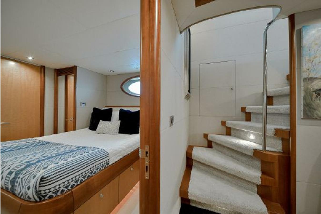 a bedroom with a bed and a staircase aboard 2007 LAZZARA 84 MOTOR Yacht for Sale