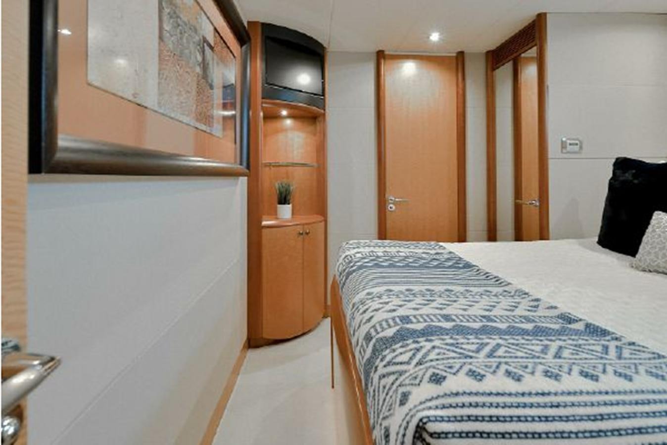 a bedroom with a bed and a closet aboard 2007 LAZZARA 84 MOTOR Yacht for Sale