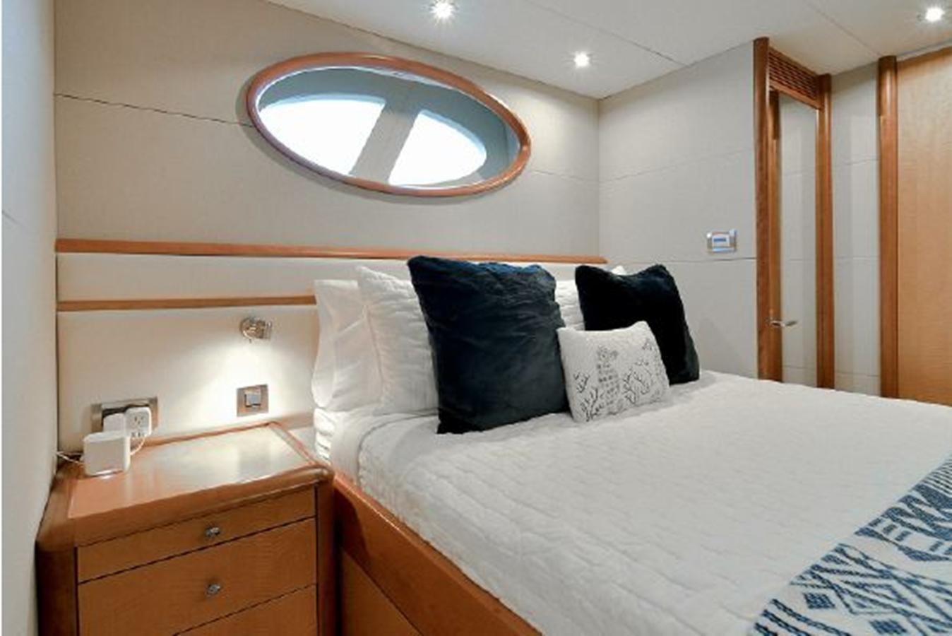 a bed with a round mirror above it aboard 2007 LAZZARA 84 MOTOR Yacht for Sale