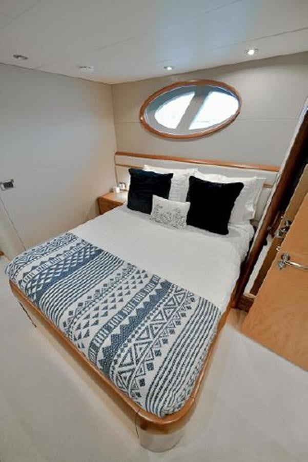 a bed with a white bed spread aboard 2007 LAZZARA 84 MOTOR Yacht for Sale