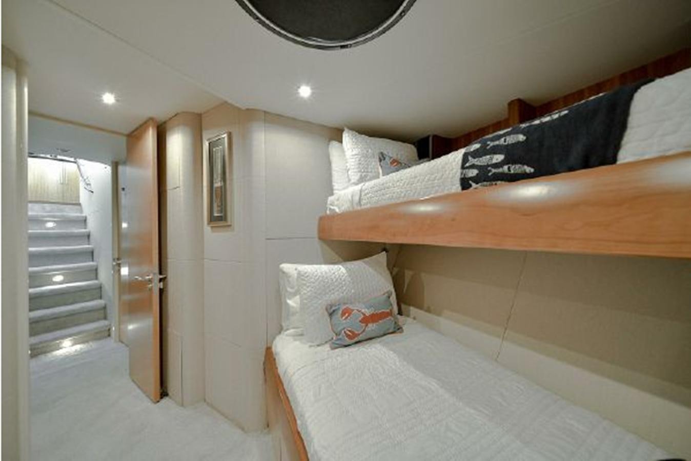 a bedroom with a bed and a wood railing aboard 2007 LAZZARA 84 MOTOR Yacht for Sale
