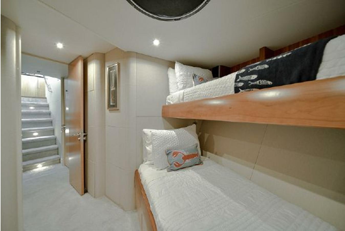a bedroom with a bed and a wood railing aboard 2007 LAZZARA 84 MOTOR Yacht for Sale