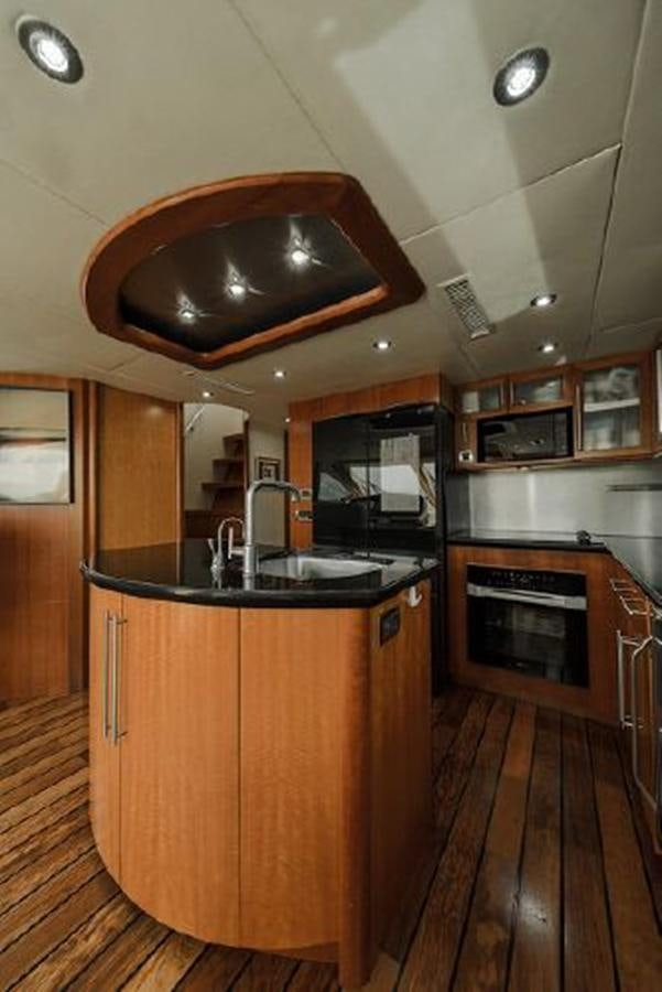 a kitchen with a wood floor aboard 2007 LAZZARA 84 MOTOR Yacht for Sale