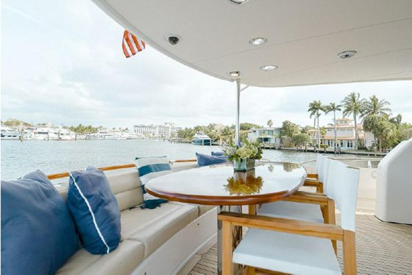 a table and chairs on a deck aboard 2007 LAZZARA 84 MOTOR Yacht for Sale