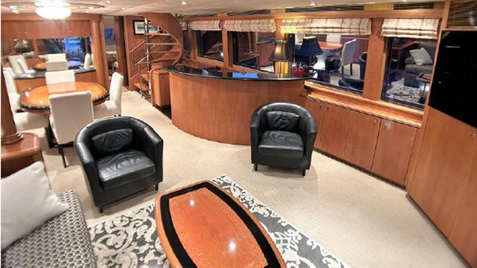 a room with a leather chair and a table and chairs aboard 2006 CHEOY LEE MOTOR Yacht for Sale