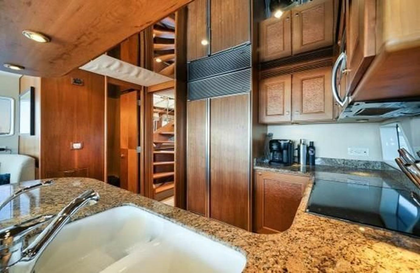 a kitchen with a sink and a large wooden cabinet aboard 2006 CHEOY LEE MOTOR Yacht for Sale