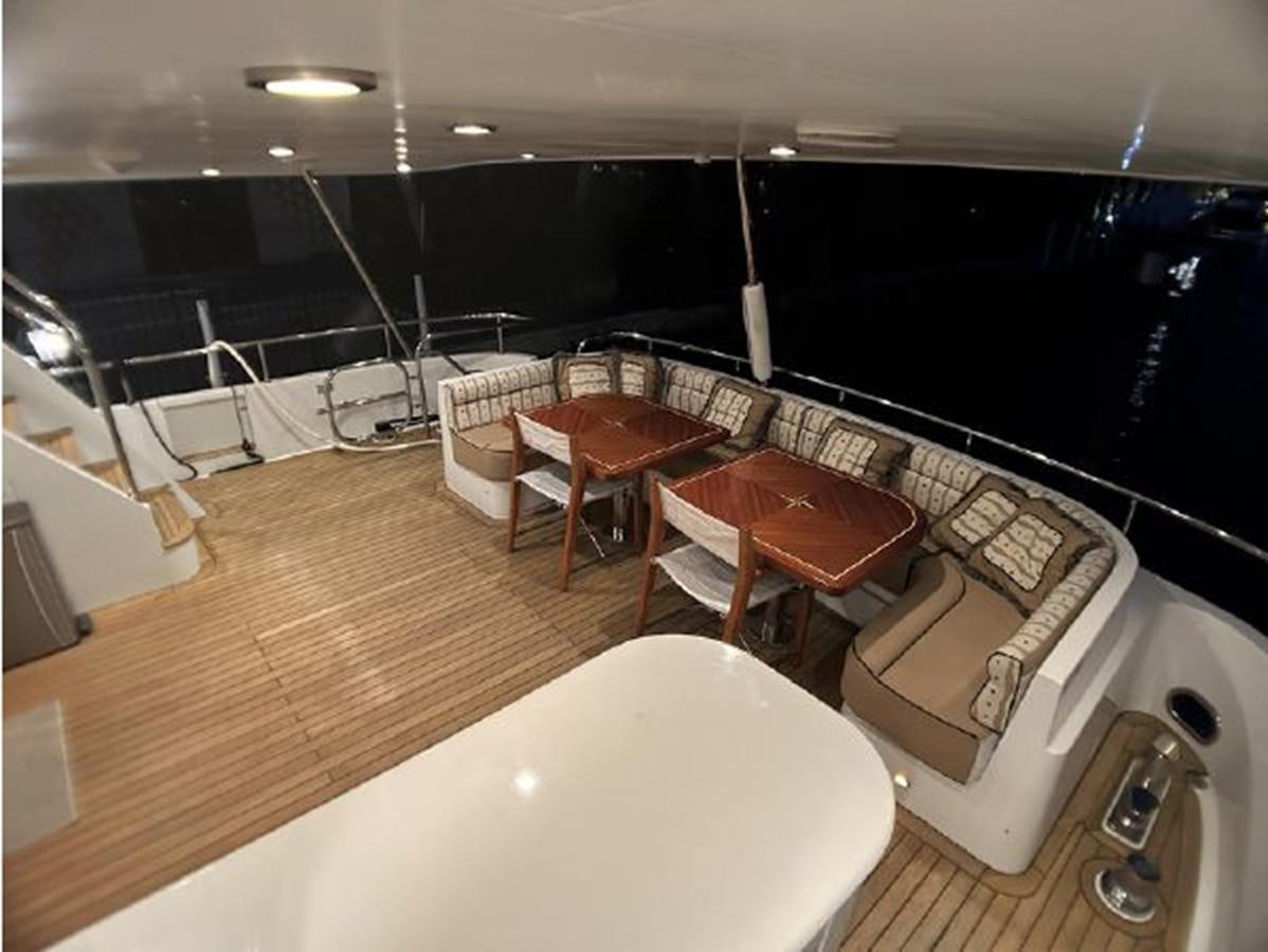 a room with a large bed and chairs aboard 2006 CHEOY LEE MOTOR Yacht for Sale